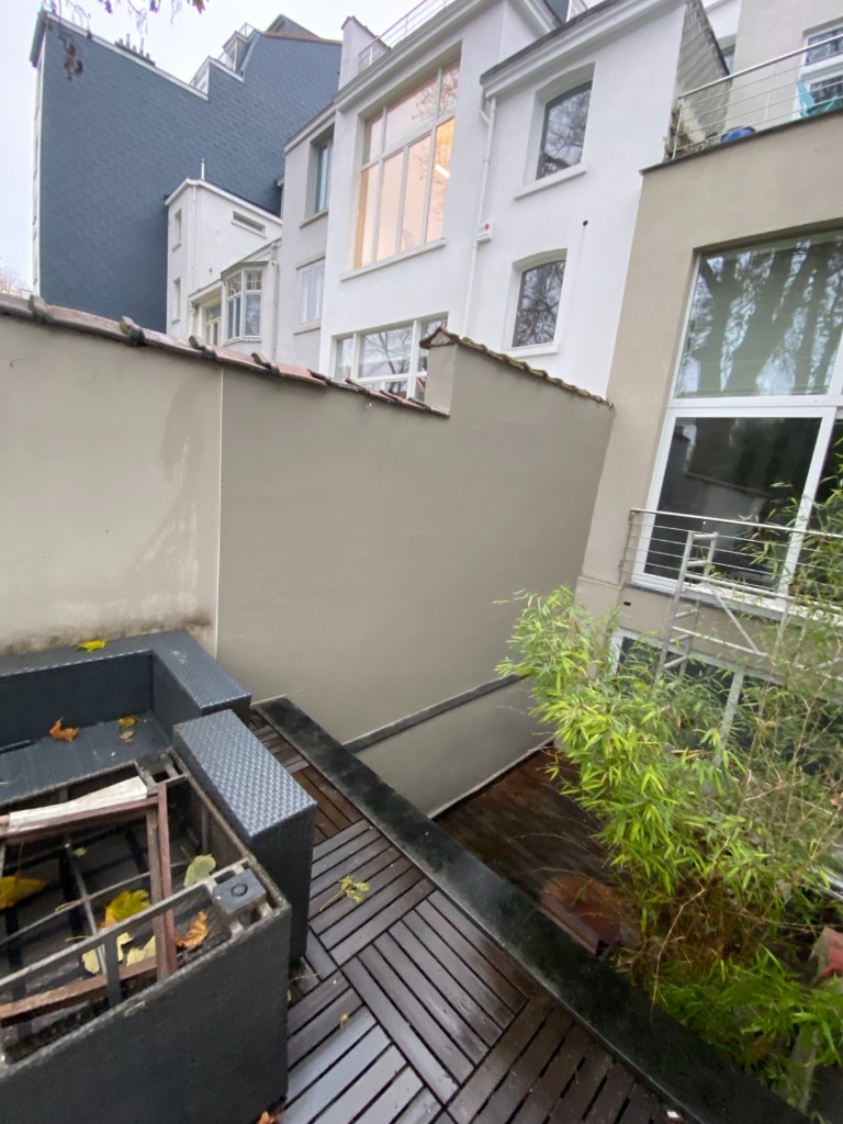 Façade terminée sur terrasse : finition lisse et couronnement en tuiles