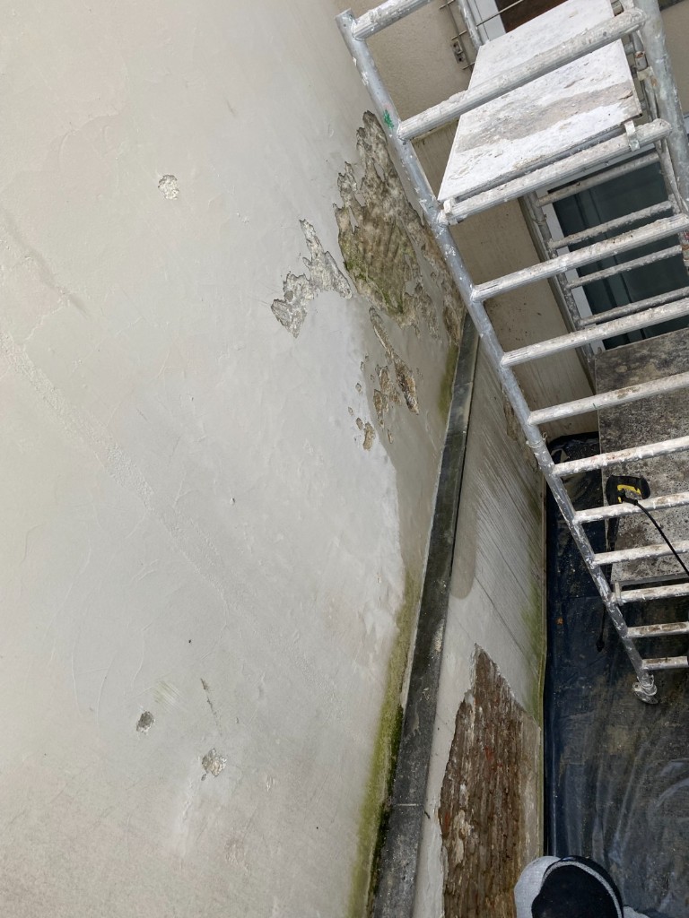 Mur extérieur dégradé avant rénovation : peinture écaillée et traces d’humidité